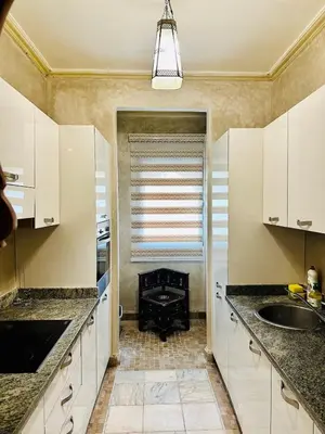 a kitchen with white cabinets and a stove at Le Palmito - 2BDR - Private Garden - Pool in Marrakech