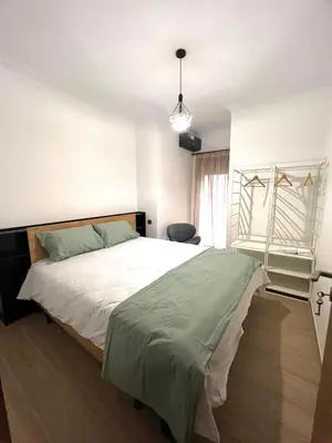 a bedroom with a large white bed and a window at Appartement magnifique in Marrakech
