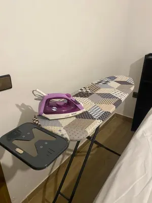 a table with a cell phone on it next to a bed at Appartement magnifique in Marrakech