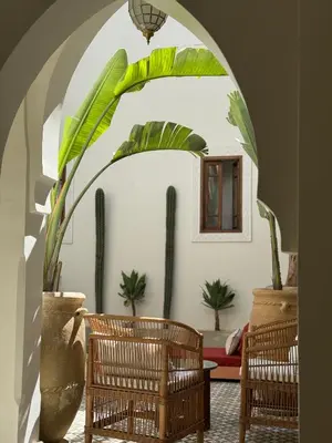 an archway with chairs and plants in a living room at Riad Dar Melia in Marrakech