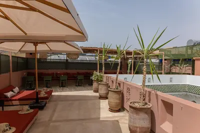 a patio with several potted plants and a pool at Riad Dar Melia in Marrakech