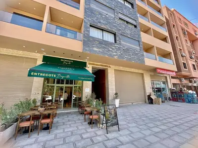 a restaurant with tables and chairs in front of a building at Modern Oasis in Gueliz - Balcony & Comfort in Marrakech
