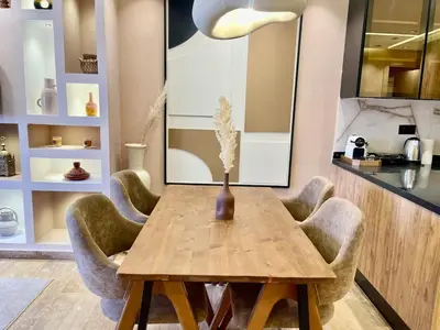 a dining room table with chairs and a vase on it at Modern Oasis in Gueliz - Balcony & Comfort in Marrakech