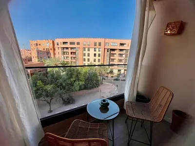 a balcony with a table and chairs and a view of a city at Modern Oasis in Gueliz - Balcony & Comfort in Marrakech