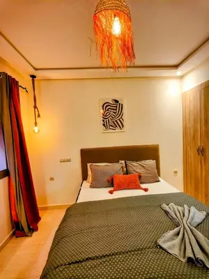 a bedroom with a bed and a chandelier at Appart chaleureux et calme, fibre et Netflix in Marrakech