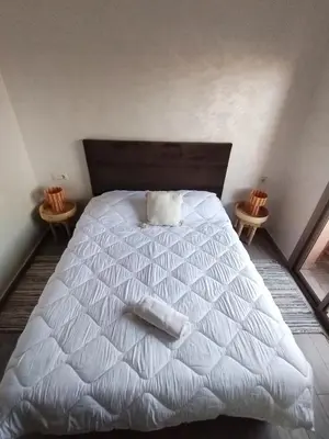 a bedroom with a white bed with two end tables at Appartement luxueux à louer in Marrakech