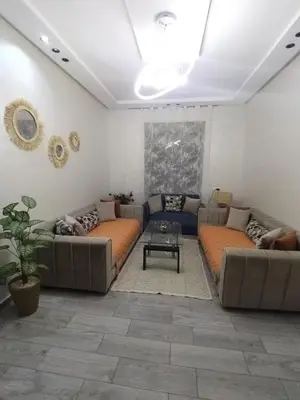 a living room with two couches and a table at Appartement luxueux à louer in Marrakech