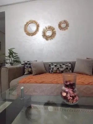 a living room with a couch and two mirrors at Appartement luxueux à louer in Marrakech