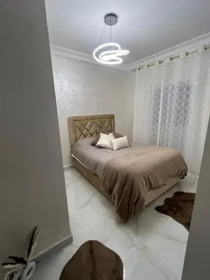 a bedroom with a bed in a white room at Appartement Cosy Marrakech in Marrakech