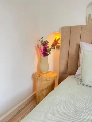 a vase with flowers sitting on a table next to a bed at Villa Elysia Marrakech, Piscine sans vis à vis in Marrakech