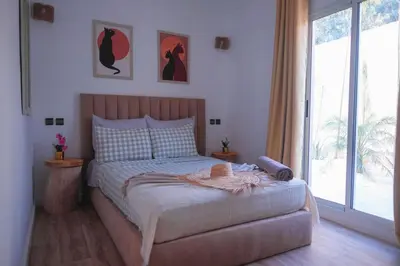 a bedroom with a bed and a large window at Villa Elysia Marrakech, Piscine sans vis à vis in Marrakech