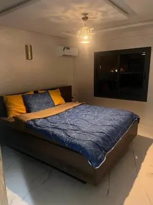 a bedroom with a bed with blue comforter and yellow pillows at Marrakech duplex apartment in Marrakech