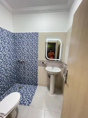 a bathroom with a sink and a toilet and a mirror at Airport Apartment in Marrakech