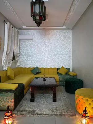 a living room with a yellow couch and a table at Airport Apartment in Marrakech