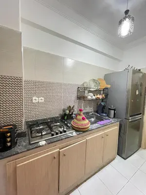 a kitchen with a stove and a stainless steel refrigerator at Airport Apartment in Marrakech