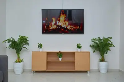 a living room with a entertainment center with a fire at appartement majorelle in Marrakech
