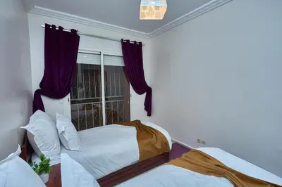a bedroom with two beds and a window at appartement majorelle in Marrakech