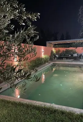 a swimming pool in front of a building at night at Magnifique villa privée piscine 3ch, centre in Marrakech