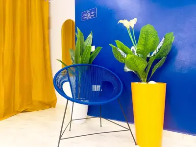 a blue chair and a yellow vase with a plant at Suite Majorelle l Gueliz,balcon,clim, Netflix,WiFi in Marrakech
