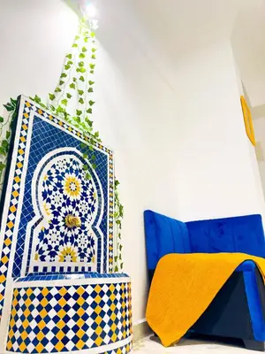 a room with a blue chair and a colorful rug at Suite Majorelle l Gueliz,balcon,clim, Netflix,WiFi in Marrakech