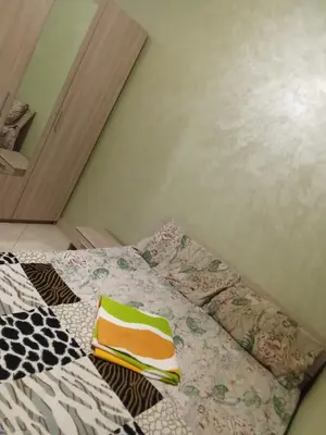 a bed with colorful pillows on it in a room at Basatine gelez in Marrakech