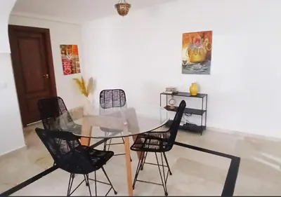 a dining room with a glass table and chairs at Appart Majorelle in Marrakech