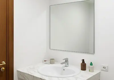 a white bathroom with a sink and a mirror at Appart Majorelle in Marrakech