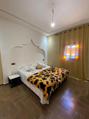 a bedroom with a bed with a cow patterned blanket at villa cherif in Azib Oulad Lâdem