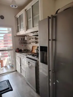 a kitchen with white cabinets and a stainless steel refrigerator at Apartment heart of Marrakech in Marrakech