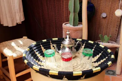 a tea pot sitting on a table with three cups at VERY RARE APARTMENT GUELIZ CENTER OF Marrakech in Marrakech