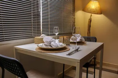 a table with a plate and wine glasses on it at VERY RARE APARTMENT GUELIZ CENTER OF Marrakech in Marrakech