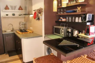 a small kitchen with a stove and a microwave at VERY RARE APARTMENT GUELIZ CENTER OF Marrakech in Marrakech