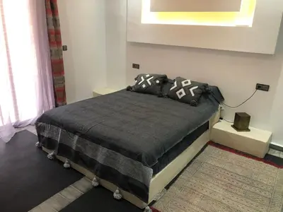 a bedroom with a bed with black and white pillows at Dar AZZARO in El Rhechat