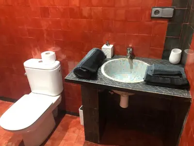 a bathroom with a white toilet and a sink at Dar AZZARO in El Rhechat