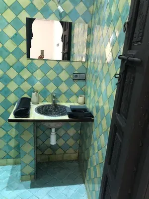 a bathroom with a sink and a mirror at Dar AZZARO in El Rhechat