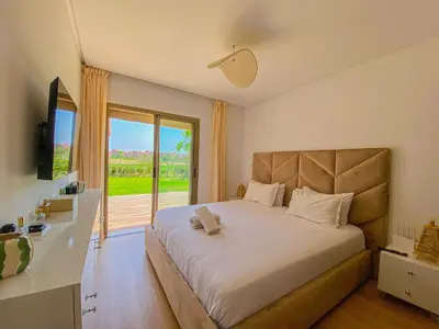 a bedroom with a large bed with a large window at Luxury Apartment in Prestigia Marrakech in Marrakech