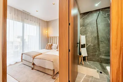 a bedroom with a bed and a walk in shower at Large Private Pool, Breakfast Included, Near Golf in El Rhechat