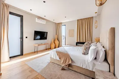 a bedroom with a large bed and a television at Large Private Pool, Breakfast Included, Near Golf in El Rhechat
