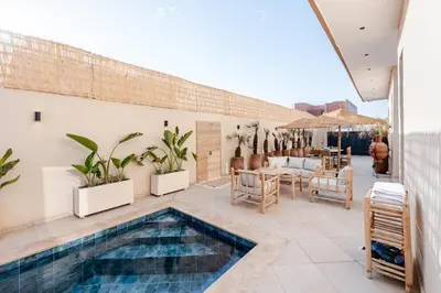 a patio with a swimming pool and a table and chairs at Large Private Pool, Breakfast Included, Near Golf in El Rhechat