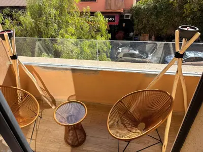 three rattan chairs sitting on a balcony with a window at Cozy Family Apartment 2BR Pool Parking Gueliz Marrakesh in Marrakech