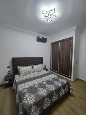 a bedroom with a bed with a black and white comforter at Cozy Family Apartment 2BR Pool Parking Gueliz Marrakesh in Marrakech