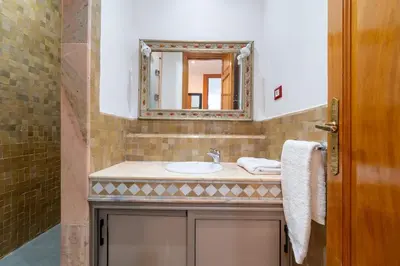 a bathroom with a sink and a mirror at Palmeraie vintage apartment with pool in Marrakech