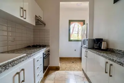 a kitchen with white cabinets and a counter top at Palmeraie vintage apartment with pool in Marrakech