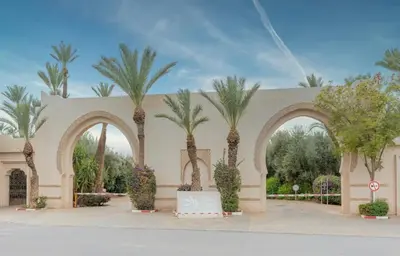 a building with palm trees in front of it at Palmeraie vintage apartment with pool in Marrakech
