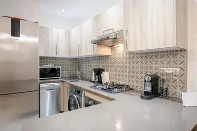 a kitchen with a refrigerator and a dishwasher at La Vita Moderna Marrakech Pool in Marrakech