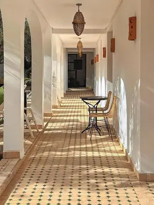a hallway with a table and chairs on a tile floor at Dariana guesthouse in Marrakech