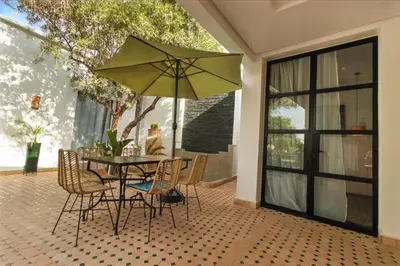 a table and chairs with an umbrella on a patio at Dariana guesthouse in Marrakech