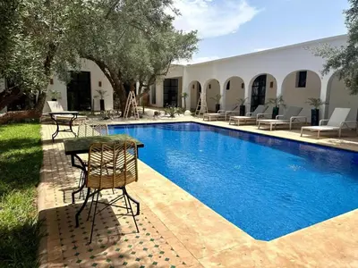 a pool with chairs and a table next to a house at Dariana guesthouse in Marrakech
