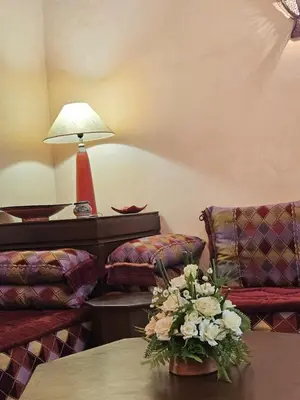 a living room with two chairs and a table with flowers at Riad zahra in Marrakech