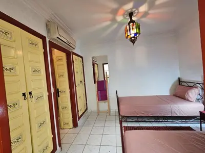 a bedroom with two beds and a chandelier at Riad zahra in Marrakech